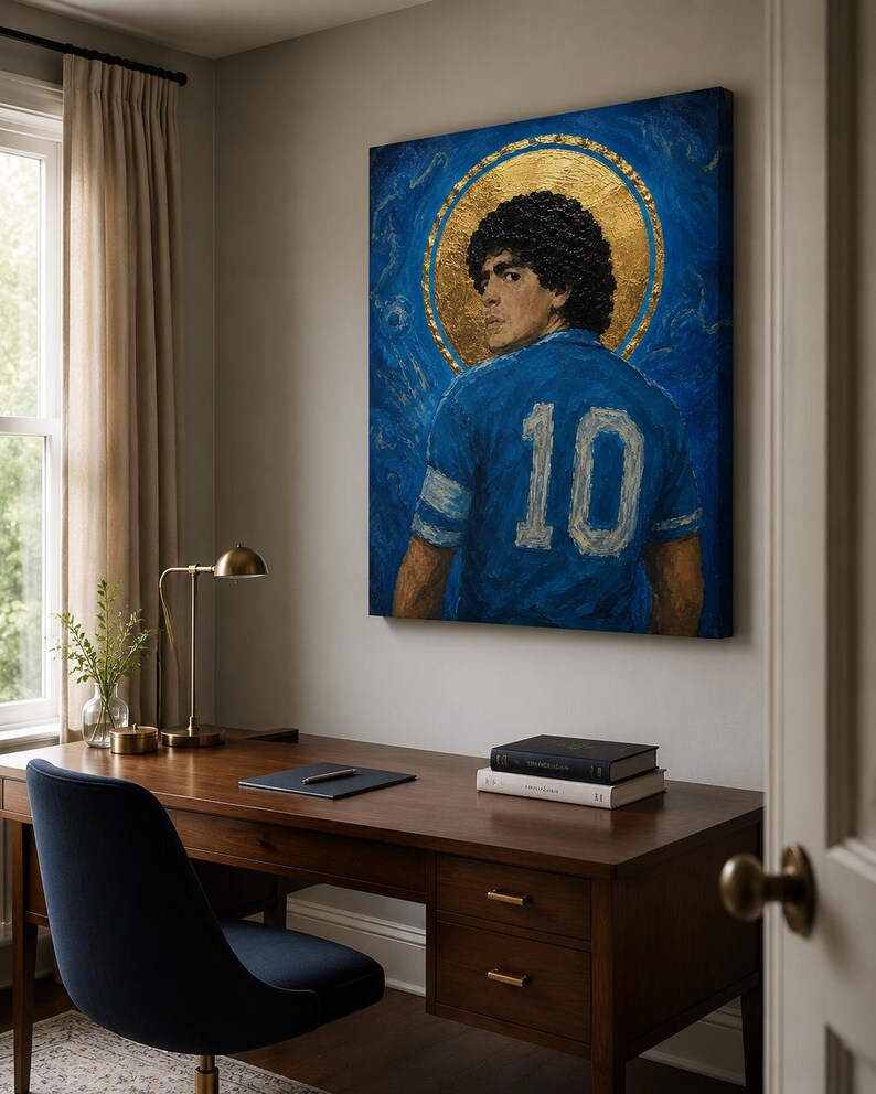 May include: A rectangular canvas painting featuring a portrait of a footballer with curly dark hair, wearing a blue jersey with the number 10 on the back. The figure is set against a deep blue background with a prominent circular gold halo.