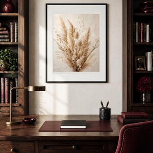 Pu&ograve; includere: Una stampa artistica incorniciata che presenta una composizione dai toni neutri di erba della pampa essiccata, baccelli e delicati fiori di campo. L'opera &egrave; esposta in una sottile cornice nera con passe-partout bianco su sfondo beige testurizzato.