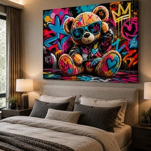 May include: A rectangular wall art canvas featuring a brown teddy bear wearing teal sunglasses and a dark jacket. The bear is set against a vibrant graffiti background with splashes of neon pink, blue, and yellow, including crown and heart motifs.