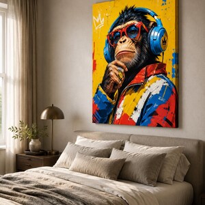 May include: A rectangular canvas wall art print featuring a stylized chimpanzee wearing blue headphones, red-rimmed glasses, and a colorful jacket with red, blue, and yellow paint splatters. The chimpanzee has a gold ring on its finger and a crown icon.