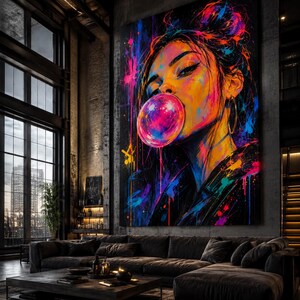 Puede incluir: Una gran pieza de arte mural rectangular que presenta un retrato vibrante y multicolor de una persona soplando una burbuja de chicle rosa. La obra utiliza salpicaduras y goteos de pintura de tonos ne&oacute;n sobre un fondo oscuro.