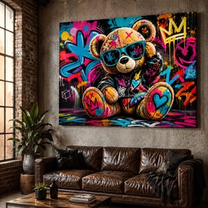 May include: A rectangular wall art print featuring a brown teddy bear wearing blue sunglasses and a dark jacket. The bear is surrounded by vibrant graffiti-style artwork including bright pink, blue, and yellow paint splatters, crowns, and hearts.