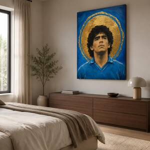 Puede incluir: Una pieza de arte mural rectangular que presenta el retrato de un hombre con cabello oscuro y rizado que viste una camisa azul con cuello. La figura se sit&uacute;a sobre un fondo azul vibrante con un gran halo circular dorado y texturizado.