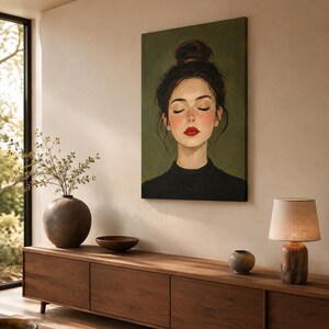 Puede incluir: Una impresi&oacute;n de arte mural rectangular que muestra el retrato de una persona con cabello oscuro recogido en un mo&ntilde;o alto, ojos cerrados y l&aacute;piz labial rojo brillante. El sujeto viste una prenda negra de cuello alto sobre un fondo verde oliva.