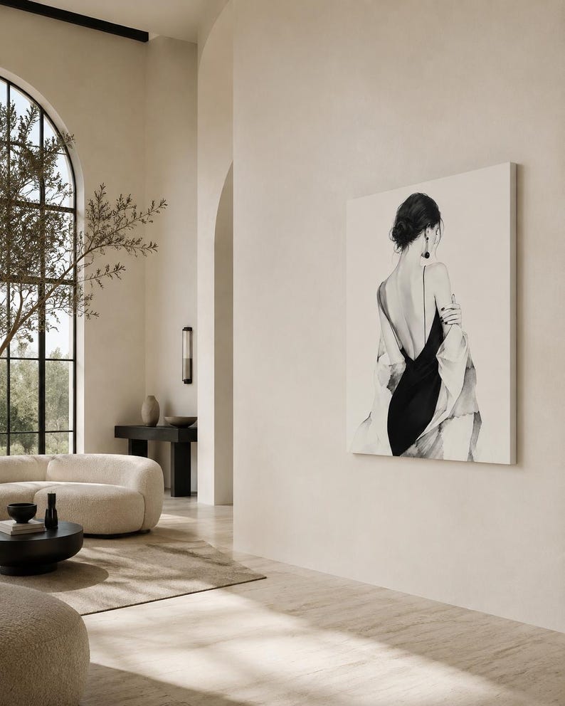 May include: A large rectangular wall art print featuring a black and white illustration of a figure seen from behind. The figure wears a black dress with thin straps and a draped light-colored garment over the shoulders, with dark hair styled up.