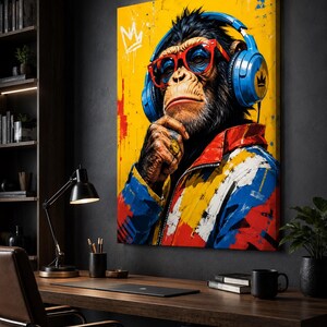 May include: A rectangular canvas wall art print featuring a chimpanzee wearing bright blue headphones, red-rimmed glasses, and a colorful jacket with red, blue, and yellow paint splatters. A white crown icon is visible in the top left corner.