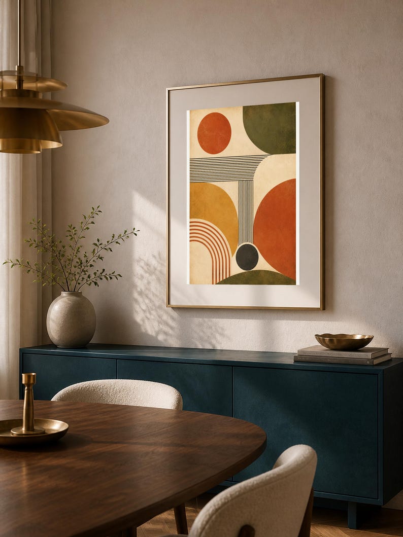Puede incluir: Una impresi&oacute;n de arte mural vertical enmarcada que presenta una composici&oacute;n abstracta de formas geom&eacute;tricas, incluyendo c&iacute;rculos, semic&iacute;rculos y l&iacute;neas paralelas en tonos naranja quemado, amarillo mostaza, verde oliva y crema.