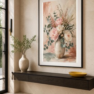 Puede incluir: Una l&aacute;mina de arte enmarcada que muestra un ramo pintado de peon&iacute;as rosas y blancas con hojas de eucalipto verdes en un jarr&oacute;n de cer&aacute;mica, sobre un fondo texturizado en tonos melocot&oacute;n y crema con pinceladas visibles y colores suaves.