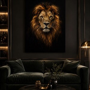 May include: A large rectangular wall art print featuring a detailed portrait of a lion with a thick, golden-brown mane against a solid black background. The lion is depicted facing forward with amber eyes, set in a dark, moody interior space.