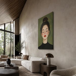 Puede incluir: Una impresi&oacute;n de arte mural rectangular que presenta el retrato de una persona con un mo&ntilde;o de cabello casta&ntilde;o oscuro, ojos cerrados y labios rojos brillantes, vistiendo una blusa negra de cuello alto sobre un fondo verde oliva s&oacute;lido.