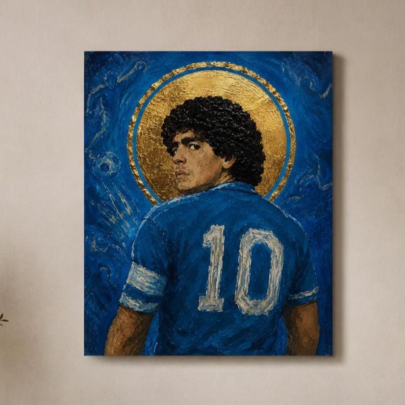 May include: An oil painting on canvas depicting a person with dark curly hair wearing a blue jersey with the number 10 on the back. The figure is positioned in front of a large, textured gold circular halo against a deep blue background.