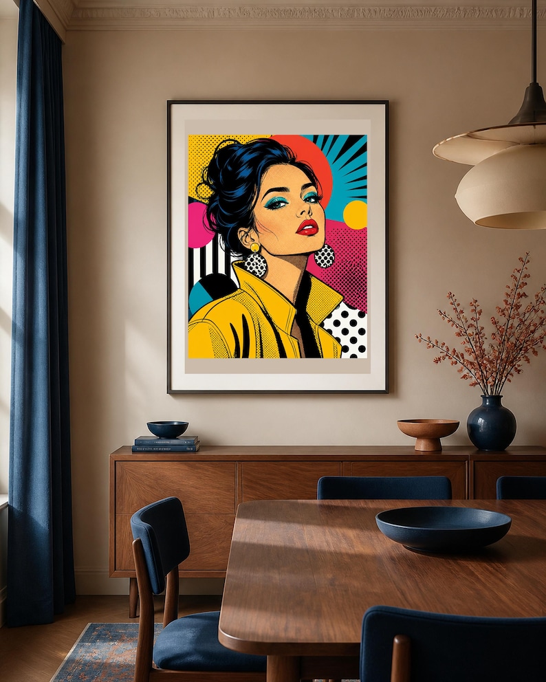 May include: A framed pop art print featuring a stylized illustration of a person with dark hair in an updo, wearing a yellow collared jacket and large circular earrings. The background incorporates vibrant geometric patterns, dots, and bold colors.