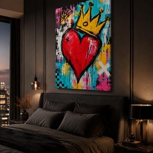 May include: A rectangular canvas wall art piece featuring a vibrant, graffiti-style painting of a large red heart topped with a yellow crown. The background is a chaotic mix of bright blue, pink, yellow, and white paint splatters and drips.