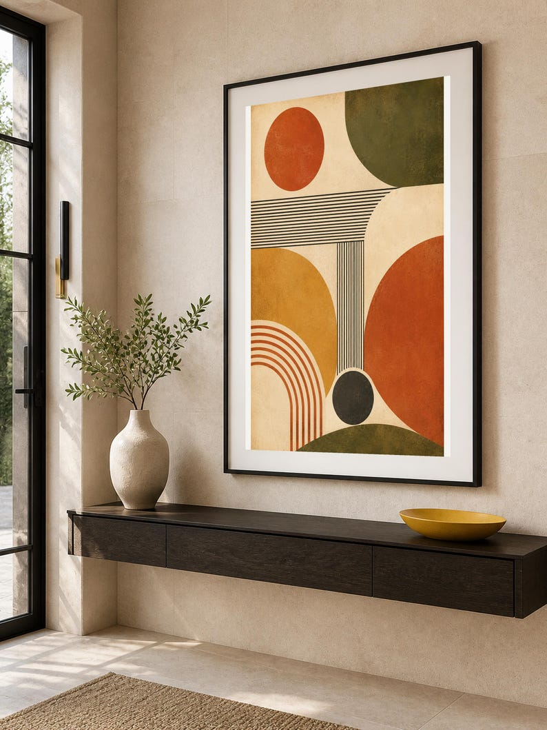 Puede incluir: Una impresi&oacute;n de arte mural vertical enmarcada que presenta formas geom&eacute;tricas abstractas, incluidos c&iacute;rculos, semic&iacute;rculos y l&iacute;neas paralelas en tonos naranja quemado, amarillo mostaza, verde oliva y negro sobre un fondo crema.