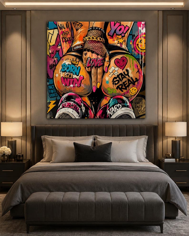 Op de afbeelding: Een vierkant kunstwerk voor aan de muur in een levendige graffitistijl. De afbeelding toont de onderrug en heupen van een persoon, versierd met kleurrijke tatoeages en teksten zoals BORN TO WIN, STAY REAL, LOVE en YO tegen een chaotische achtergrond.