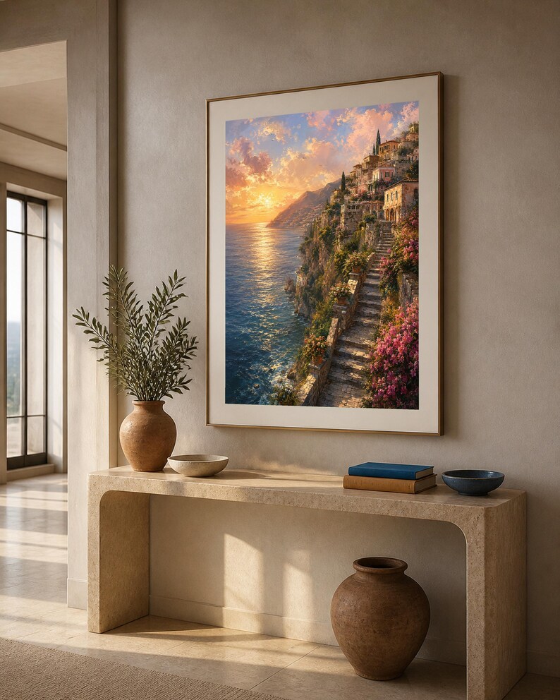 Peut inclure: Une impression d'art mural verticale encadr&eacute;e repr&eacute;sentant un village c&ocirc;tier m&eacute;diterran&eacute;en au coucher du soleil, avec des escaliers en pierre, des bougainvilliers roses et une lumi&egrave;re dor&eacute;e sur la mer, pos&eacute;e sur une console beige avec poterie.
