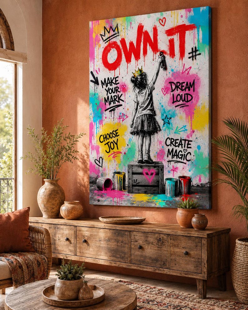 May include: A rectangular wall art canvas featuring a black and white illustration of a child wearing a crown and standing on a crate, painting the red text OWN IT. The background is filled with colorful graffiti splashes and motivational phrases.