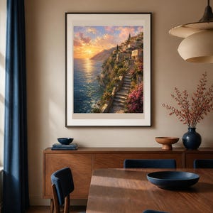 Peut inclure: Une impression d'art mural verticale encadr&eacute;e repr&eacute;sentant un paysage c&ocirc;tier m&eacute;diterran&eacute;en au coucher du soleil. La sc&egrave;ne montre des b&acirc;timents en pierre sur une falaise, un escalier sinueux, des fleurs roses et un soleil dor&eacute; sur l'oc&eacute;an.