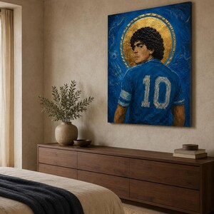 May include: A rectangular canvas painting featuring a portrait of a footballer with curly dark hair, wearing a blue jersey with the number 10 on the back. The figure is centred against a deep blue background with a prominent gold circular halo.