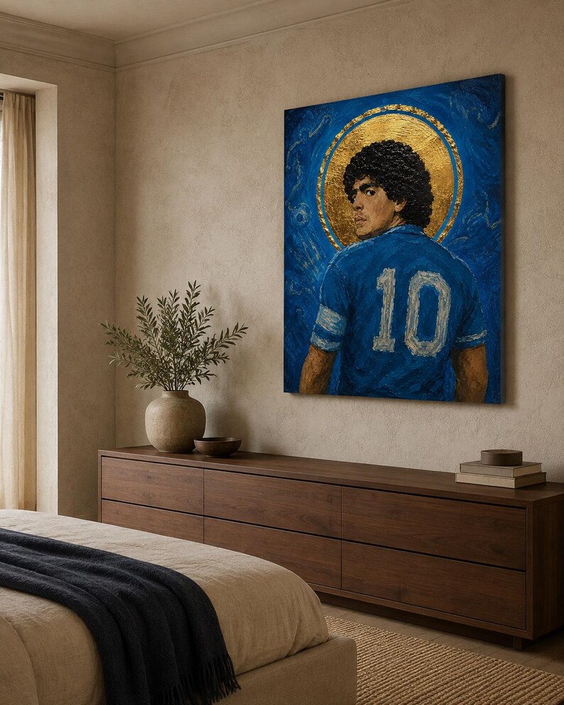 May include: A rectangular canvas painting featuring a portrait of a footballer with curly dark hair, wearing a blue jersey with the number 10 on the back. The figure is centred against a deep blue background with a prominent gold circular halo.