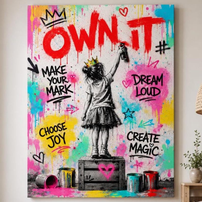 May include: A canvas print featuring a child wearing a crown standing on a wooden crate, holding a spray paint can. The background is a vibrant graffiti-style wall with splashes of pink, yellow, and blue paint, and the text OWN IT, MAKE YOUR MARK, DREAM LOUD, CHOOSE JOY, and CREATE MAGIC.