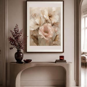 May include: A framed wall art print featuring a soft-toned floral illustration of large, layered petals in shades of cream, beige, and muted pink, set against a neutral background with delicate stems and leaves in earthy brown tones.