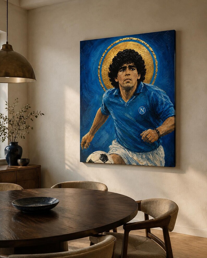 May include: A rectangular oil painting on canvas depicting a soccer player with dark curly hair wearing a blue jersey with a white N logo and white shorts. A large gold circular halo is painted behind the head against a deep blue background.