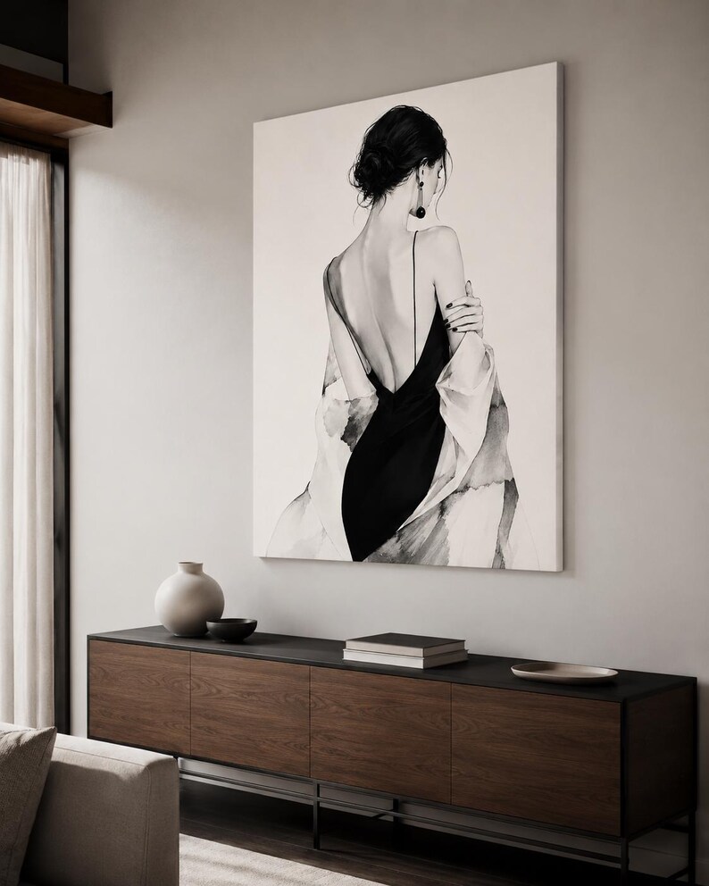 May include: A large rectangular wall art print featuring a black and white illustration of a person seen from the back. The figure wears a black slip dress with thin straps and a draped white garment over the shoulders, with dark hair in a bun.