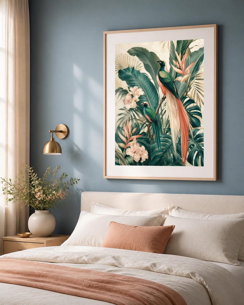 Puede incluir: Una l&aacute;mina de arte enmarcada que muestra dos aves quetzal posadas entre un exuberante follaje tropical, grandes hojas verdes de monstera y flores de color rosa p&aacute;lido. La obra est&aacute; en un marco de madera clara con un borde de paspart&uacute; blanco.