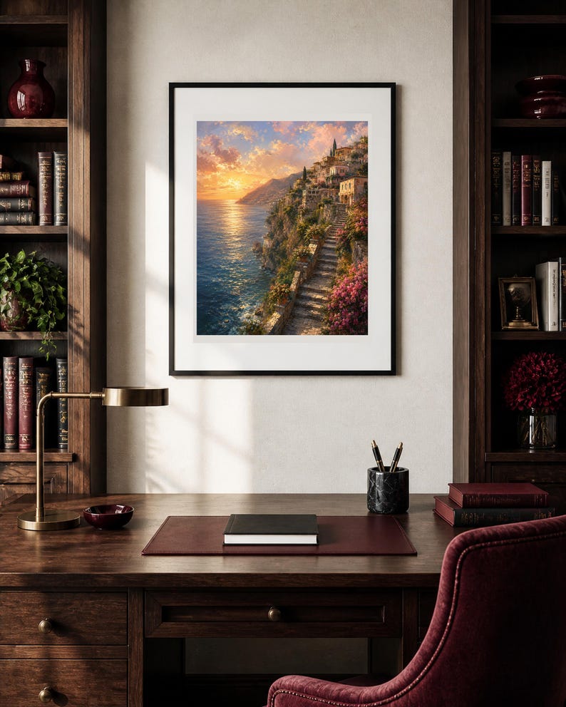 Peut inclure: Une impression d'art mural verticale encadr&eacute;e repr&eacute;sentant un village c&ocirc;tier &agrave; flanc de falaise au coucher du soleil. La sc&egrave;ne montre des escaliers en pierre, des fleurs roses et des b&acirc;timents surplombant une mer bleue sous un ciel dor&eacute;, dans un cadre noir.
