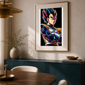 May include: A framed wall art print featuring a stylized illustration of a character with spiky dark hair, wearing blue and yellow armor with shoulder pads, standing with arms crossed against a solid black background in a vibrant color palette.