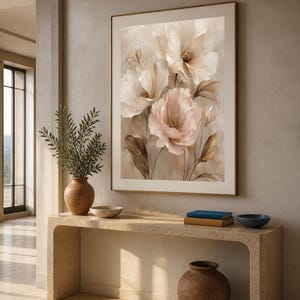 May include: A framed wall art print featuring a soft-toned floral illustration with large, layered petals in shades of cream, pale pink, and muted brown. The artwork displays delicate brushwork and organic shapes, presented in a thin gold frame.