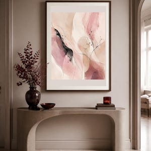 K&ouml;nnte beinhalten: Ein gerahmter, rechteckiger Wandkunstdruck mit abstrakten, flie&szlig;enden Formen in Puderrosa, Creme und tiefem Burgunderrot, akzentuiert durch feine schwarze Linien und zarte, botanisch anmutende Striche auf beigem Hintergrund.