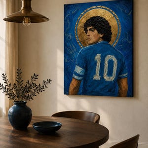 May include: A rectangular canvas painting depicting a football player with curly dark hair wearing a blue jersey with the number 10 in white. The player is positioned in front of a circular gold leaf halo against a textured deep blue background.