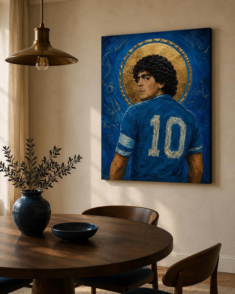 May include: A rectangular canvas painting depicting a football player with curly dark hair wearing a blue jersey with the number 10 in white. The player is positioned in front of a circular gold leaf halo against a textured deep blue background.