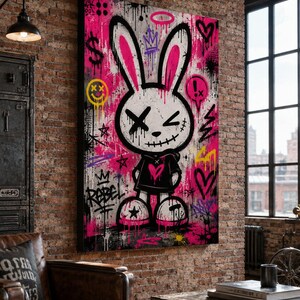 May include: A rectangular wall art canvas featuring a white cartoon rabbit with long ears, wearing a black hoodie with a pink heart. The background is a vibrant pink and black graffiti-style design with symbols including a dollar sign, hearts, and the word Rebel.