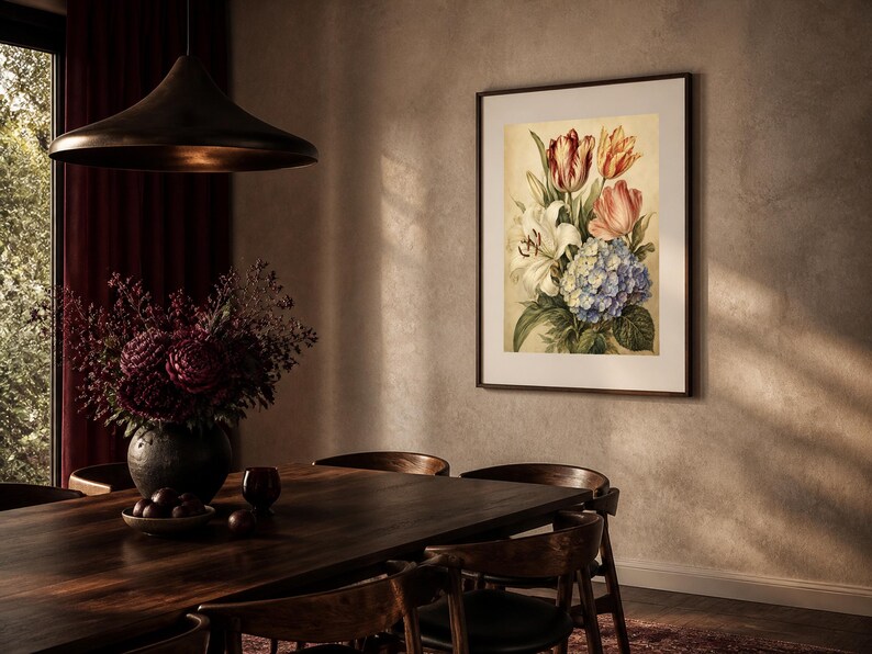 May include: A framed botanical wall art print featuring a bouquet of flowers including red and orange tulips, a white lily, and a cluster of blue hydrangea blossoms, displayed in a dark brown frame on a textured light beige wall.