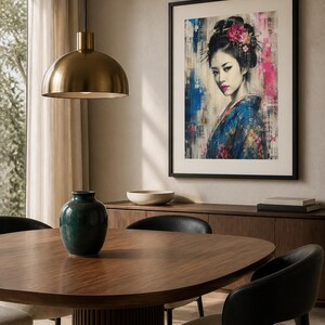 Puede incluir: Una impresi&oacute;n de arte mural enmarcada que presenta el retrato de una persona con cabello oscuro recogido en un mo&ntilde;o con flores rosas, vistiendo una prenda azul estampada, acentuada por salpicaduras abstractas de pintura azul y rosa.