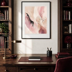 K&ouml;nnte beinhalten: Ein gerahmter abstrakter Wandkunstdruck mit flie&szlig;enden, geschichteten Formen in Nuancen von zartem Rosa, Creme und tiefem Burgunderrot. Die Komposition enth&auml;lt feine schwarze Tintenlinien, dezente Spritzer und weiche Farbverl&auml;ufe in einem schwarzen Rahmen.