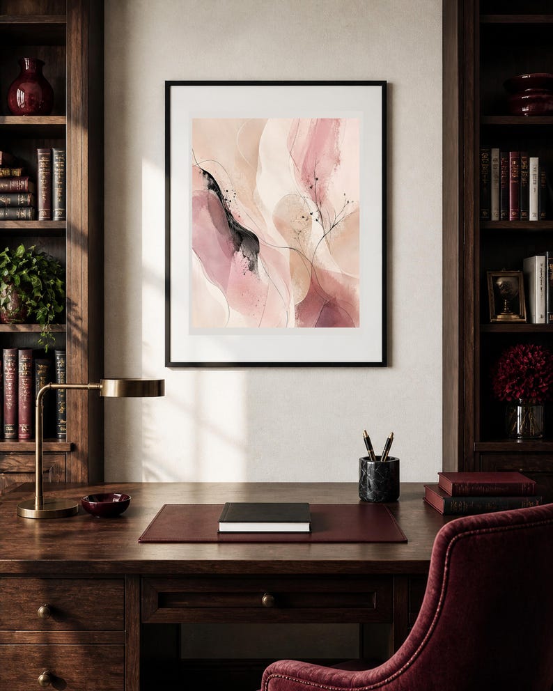 K&ouml;nnte beinhalten: Ein gerahmter abstrakter Wandkunstdruck mit flie&szlig;enden, geschichteten Formen in Nuancen von zartem Rosa, Creme und tiefem Burgunderrot. Die Komposition enth&auml;lt feine schwarze Tintenlinien, dezente Spritzer und weiche Farbverl&auml;ufe in einem schwarzen Rahmen.