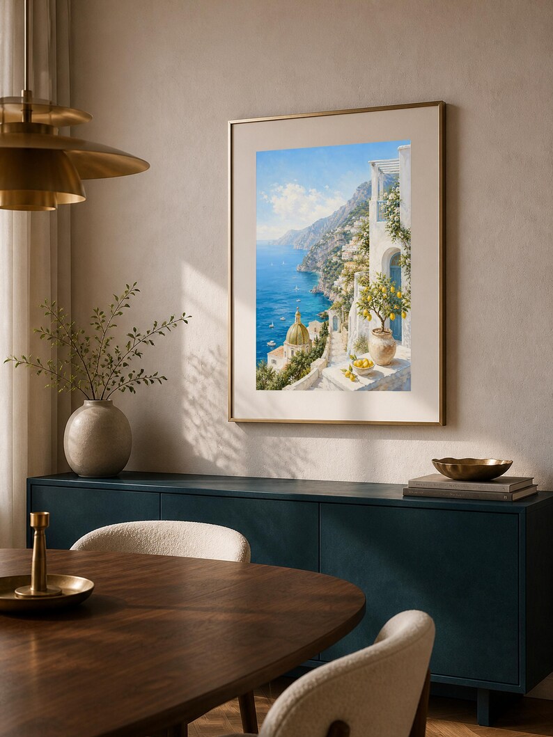 May include: A framed vertical wall art print depicting a coastal Mediterranean scene with white buildings, a golden dome, and a lemon tree in the foreground overlooking a deep blue sea under a bright sky, displayed in a neutral-toned room.