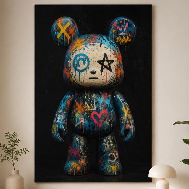 Op de afbeelding: Een verticale wandkunstprint met een gestileerd berenfiguur tegen een effen zwarte achtergrond. De beer is bedekt met levendige graffiti-achtige verfspatten, waaronder blauw, oranje en roze, met symbolen zoals een ster, hart en kroon.