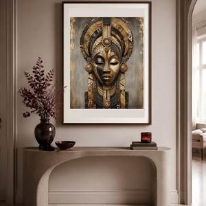 Puede incluir: Una l&aacute;mina de arte enmarcada que presenta un retrato estilizado de un rostro con intrincados patrones geom&eacute;tricos dorados y negros, adornos circulares en las orejas y un tocado alto y ornamentado, expuesta en una habitaci&oacute;n de tonos neutros.