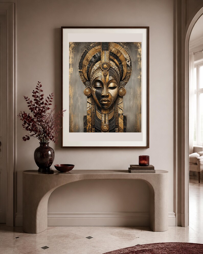 Puede incluir: Una l&aacute;mina de arte enmarcada que presenta un retrato estilizado de un rostro con intrincados patrones geom&eacute;tricos dorados y negros, adornos circulares en las orejas y un tocado alto y ornamentado, expuesta en una habitaci&oacute;n de tonos neutros.