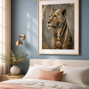 May include: A framed wall art print featuring a stylized lioness in profile. The lioness has intricate gold, brown, and black geometric patterns on its fur and wears three circular gold medallions around its neck against a textured gray background.
