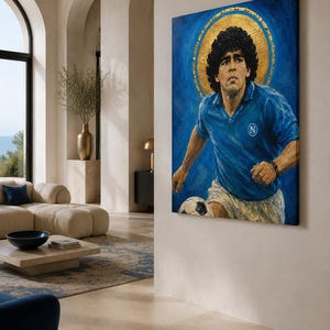 May include: A rectangular canvas painting depicting a soccer player with curly dark hair wearing a blue jersey with a white N logo and white shorts. The player is positioned against a deep blue background with a prominent gold circular halo.