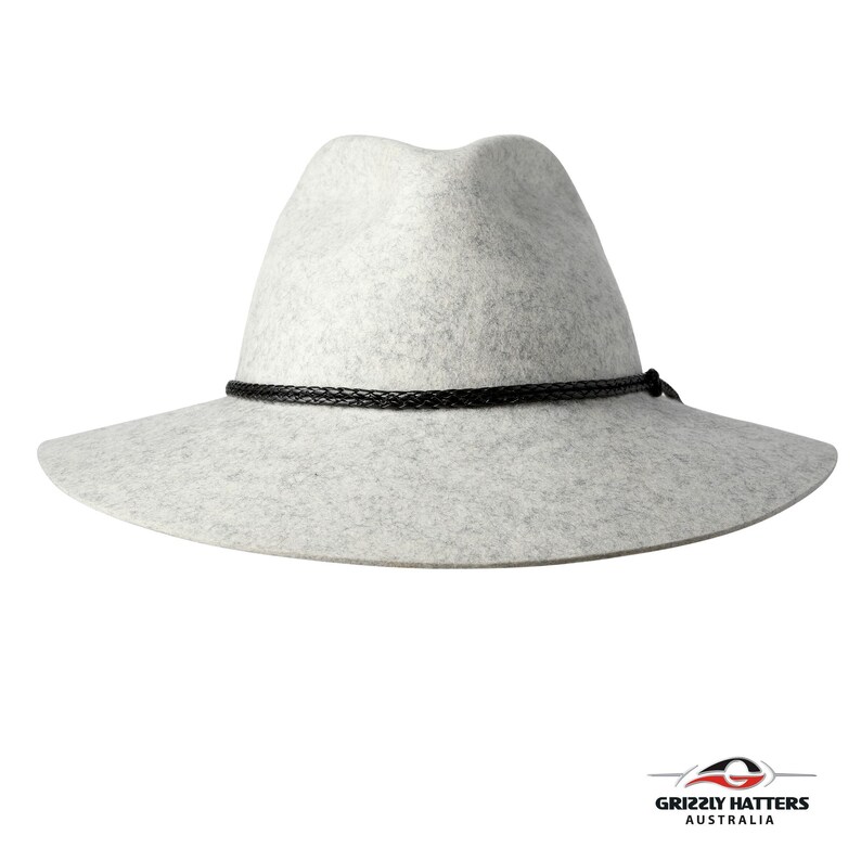 Op de afbeelding: Een lichtgrijze wollen fedora-hoed met een zwarte gevlochten band rond de kroon.