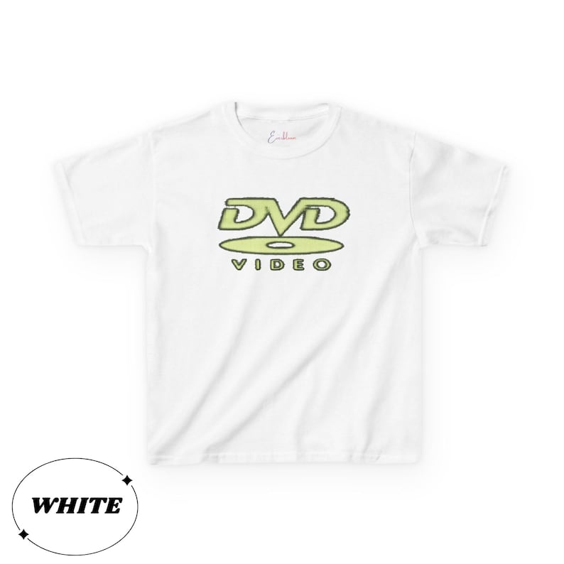 May include: A white short-sleeved t-shirt featuring a light green graphic on the chest. The graphic displays the text DVD VIDEO with the letters DVD positioned above a stylized disc icon. A small red script logo is printed near the neckline.