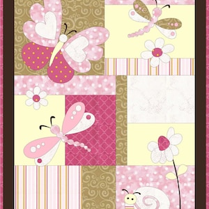 Op de afbeelding: Een roze en bruine patchworkdeken met een vlinder-, libellen- en slakkenontwerp. De deken heeft verschillende patronen, waaronder stippen, strepen en swirls.