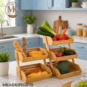 May include: A three-tier bamboo storage stand featuring open-slatted baskets. The stand holds various food items including bread loaves, a round bun, green onions, red tomatoes, a carrot, a green bell pepper, a red onion, and a head of broccoli.